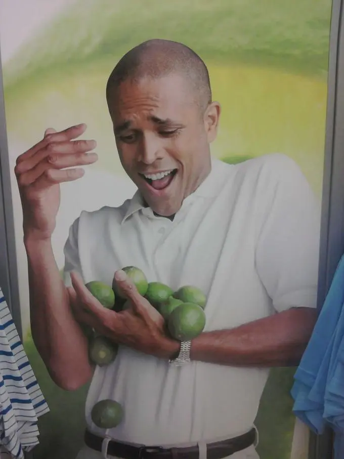 a human holding far too many limes